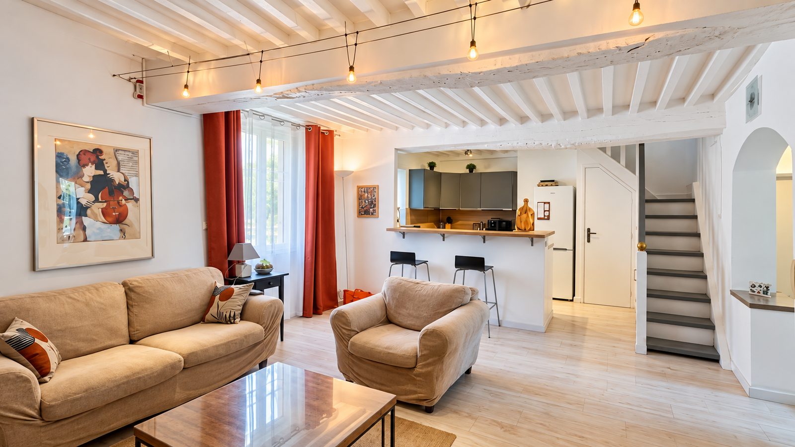 Salon avec poutres apparentes et coin cuisine ouvert