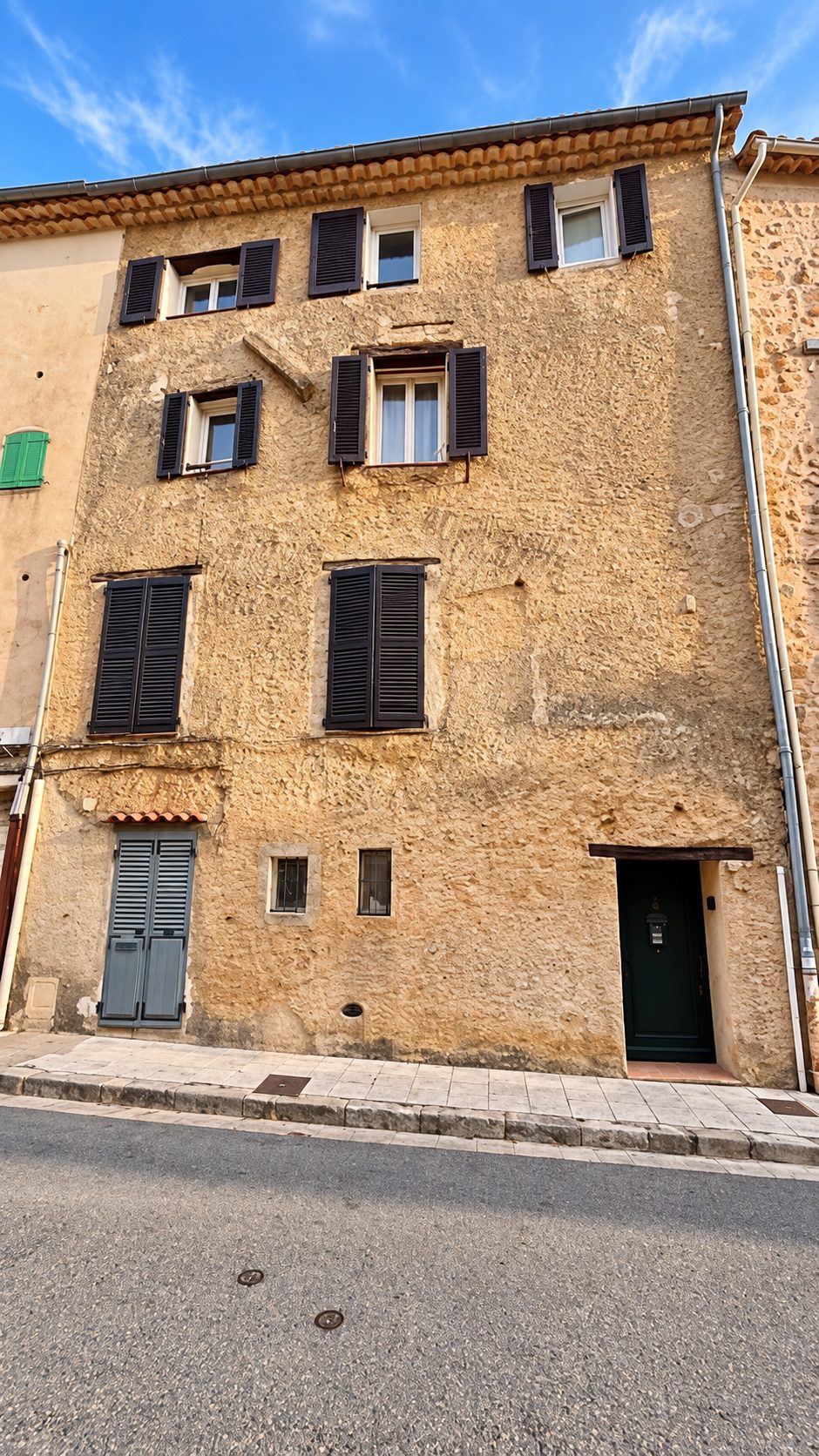 Façade en pierre du village avec volets