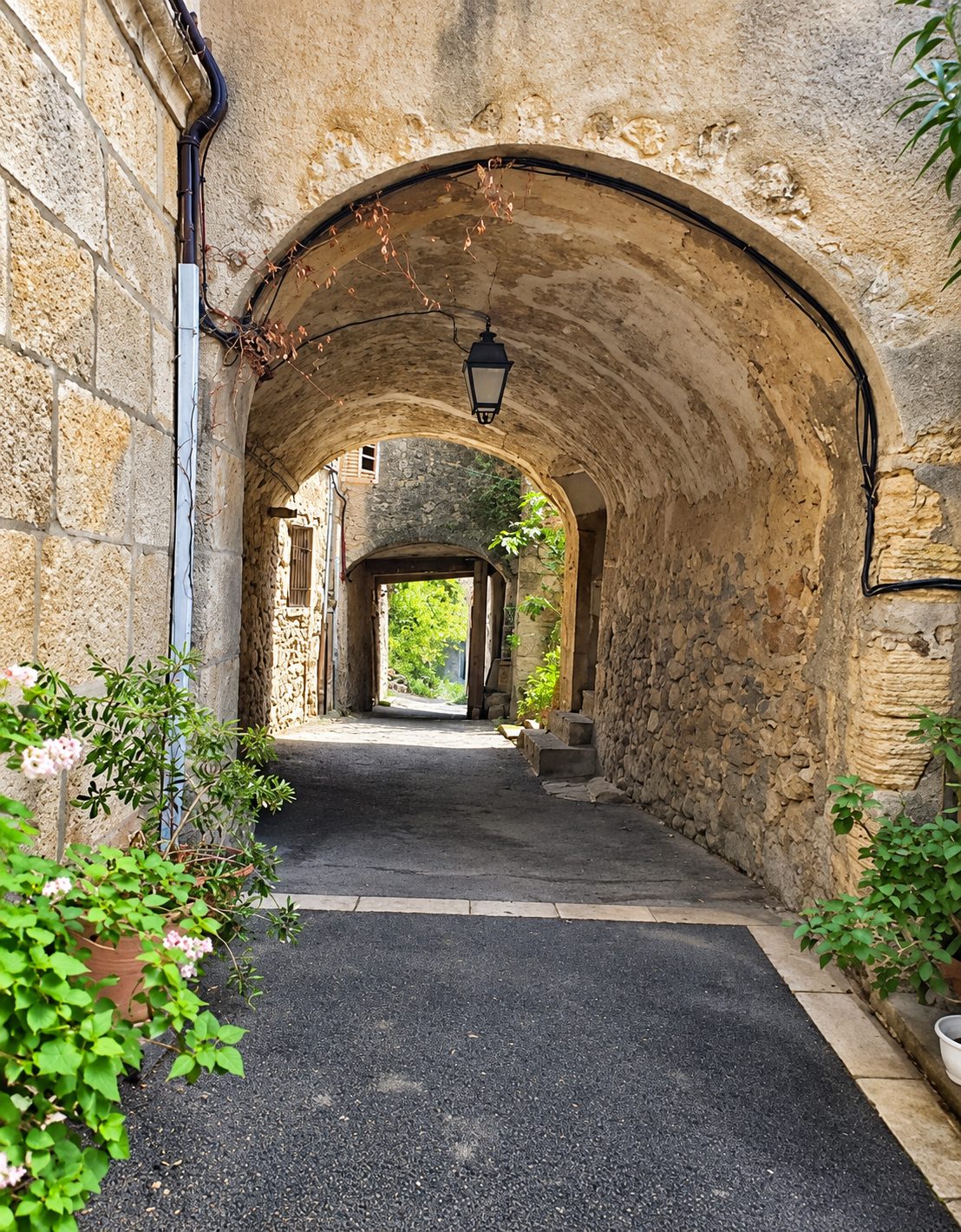 Passage voûté en pierre menant à la ruelle
